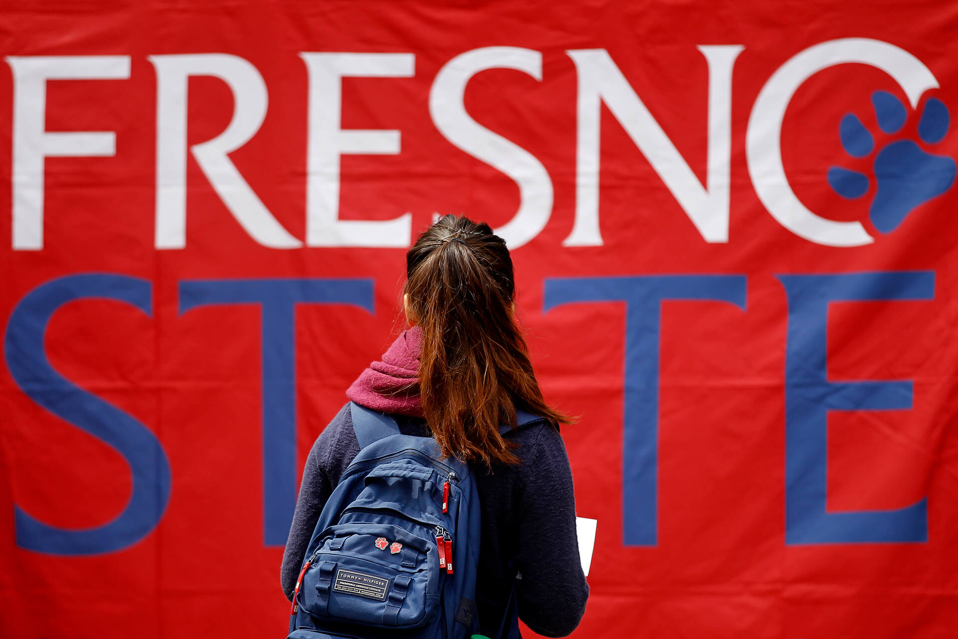 Female student looking at a Fresno State banner