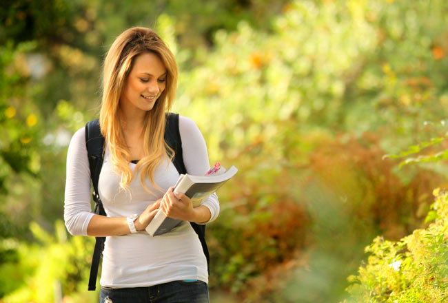 Student Holding Notebook Surrounded by Nature