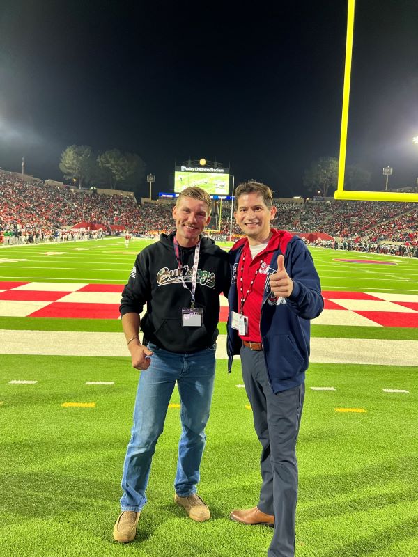 two men standing on football field